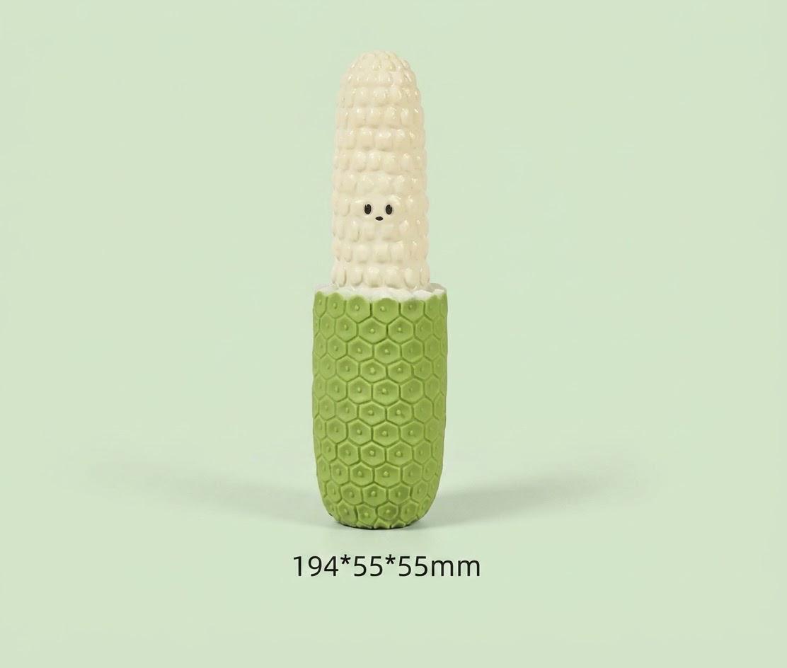 Corn-shaped squeaky dog toy with a green textured base