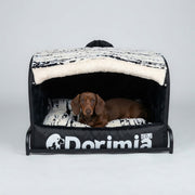 Dachshund resting in a cozy enclosed black dog bed